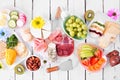 Spring or Easter theme charcuterie table scene against white wood. Top down view. Royalty Free Stock Photo