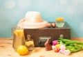 Spring and easter travel concept. Vintage wooden suitcase, hat, chocolate eggs, chocolate bunny, lemonade and tulip flowers Royalty Free Stock Photo