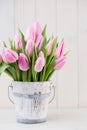 Spring easter tulips in bucket on white vintage background. Royalty Free Stock Photo