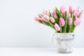 Spring easter tulips in bucket on white vintage background. Royalty Free Stock Photo