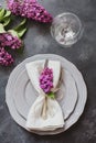 Spring elegant table place setting with violet lilac, silverware on vintage table. View from above. Royalty Free Stock Photo