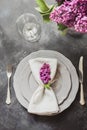 Spring elegant table place setting with violet lilac, silverware on vintage table. View from above. Royalty Free Stock Photo