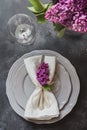 Spring elegant table place setting with violet lilac, silverware on vintage table. View from above. Royalty Free Stock Photo