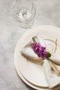 Spring elegant table place setting with violet lilac, silverware on vintage table. View from above. Royalty Free Stock Photo