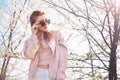 Spring fashion girl outdoors portrait in blooming trees. Beauty Romantic woman in flowers in sunglasses. Sensual Lady. Royalty Free Stock Photo