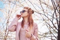 Spring fashion girl outdoors portrait in blooming trees. Beauty Romantic woman in flowers in sunglasses. Sensual Lady.