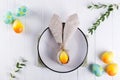 Spring festive Easter table setting with bunny ears linen napkin and kitchen cutlery. Flat lay