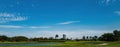 Spring field landscape with green grass, trees and cloudy blue sky. Golf course. Royalty Free Stock Photo