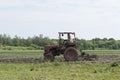 Spring field work. Ukraine. A man on a tractor cultivates the land for the sowing of agrotechnical plants.