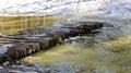 Spring flood - a bridge made of logs across a small river, which overflowed from melting snow Royalty Free Stock Photo