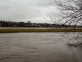 Spring flood. The river overflowed its banks and overflowed. A view of a small town across the river. Very gloomy weather