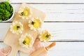 Spring flower shaped lemon tarts with bees, above view scene over a white wood background with copy space