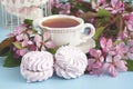 Spring flowers background with tea cup and sweet cookies Royalty Free Stock Photo