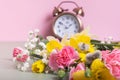 Spring flowers daffodils and willow with defocused alarm clock. Spring time, daylight savings concept, spring forward Royalty Free Stock Photo