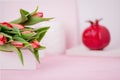 Spring flowers red tulips and ceramic pomegranate fruit on a white pink background. Copy space Royalty Free Stock Photo