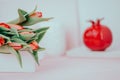 Spring flowers red tulips and ceramic pomegranate fruit on a white pink background. Copy space, toned Royalty Free Stock Photo