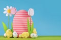 Spring flowers and wooden Easter egg with chicks in front of blue background Royalty Free Stock Photo