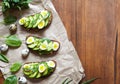 Spring food. A whole grain bread toast sandwich with avocado, spinach, guacamole and quail eggs on parchment. Royalty Free Stock Photo