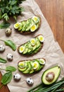 Spring food. A whole grain bread toast sandwiches with avocado, spinach, guacamole, arugula and quail eggs on parchment Royalty Free Stock Photo