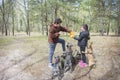 In the spring in the forest a girl and a boy train three French Bulldog dogs