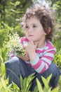 Spring in the forest little girl holding a small bouquet lily of