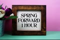 Spring Forward 1 Hour message with tulip flower in metal vase Royalty Free Stock Photo