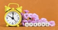 Spring forward, springtime, daylight savings time concept, yellow clock and flowers on orange background Royalty Free Stock Photo