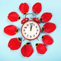 Spring forward time. Stylish vintage red alarm clock. Daylight savings time concept. Alarm clock with tulip petals around. Flat Royalty Free Stock Photo