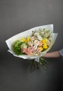 Spring fresh bouquet of flowers and greenery, approaching spring in the hand