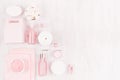 Spring fresh cosmetic products for makeup and bath in pastel pink color on white wooden board as decorative border, top view. Royalty Free Stock Photo