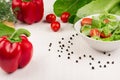 Spring fresh salad of green spinach, cherry tomato slices, red paprika in white bowl on white wood background, closeup, copy space Royalty Free Stock Photo