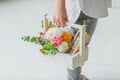 Spring gift in the hands of women. Flower arrangement in a white wooden box. Cakes with almond cookies, green branches, Rowan,