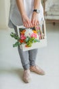 Spring gift in the hands of women. Flower arrangement in a white wooden box.