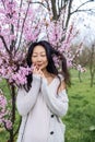 portrait of tender asian woman at sakura flowers background. Hanami celebration in sakura blooming garden