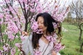 portrait of tender asian woman at sakura flowers background. Hanami celebration in sakura blooming garden