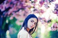 Spring girl face. Close up portrait of tender woman at sakura flowers background. Hanami celebration in sakura blooming