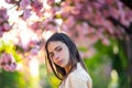 Spring girl face. Close up portrait of tender woman at sakura flowers background. Hanami celebration in sakura blooming