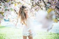 Spring girl in short pink dress enjoying sunny day in garden. Female playing with long gorgeous blond hair, beauty and Royalty Free Stock Photo