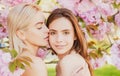 Spring girls face. Beautiful sensual sexy woman in pink flowers in summer blossom park. Lesbian couple kissing. Sensual Royalty Free Stock Photo