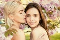 Spring girls face. Beautiful sensual sexy woman in pink flowers in summer blossom park. Lesbian couple kissing. Sensual Royalty Free Stock Photo