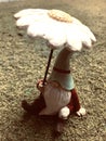 Mini gnome under a flower umbrella