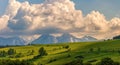 Spring green mountain landscape with meadows and rocky peaks. Landscape with a chapel and snow-covered Tatra Mountains Royalty Free Stock Photo