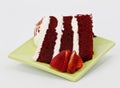 Spring green plate holds three layer red velvet cake slice Royalty Free Stock Photo