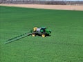 John Deere R4038 self propelled sprayer applying herbicide to winter wheat