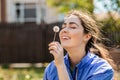 Spring and happiness. Portrait of a Young woman holding a dandelion and holding it to her face with a smile and closed eyes Royalty Free Stock Photo