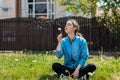 Spring and happiness. A young woman sits on the lawn of her yard and blows out a dandelion Royalty Free Stock Photo