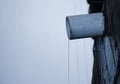 A jet of melt or rainwater flows through an asbestos pipe in a multi-storey building