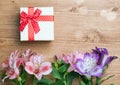 Spring is here. Gift box and tulips on wooden background