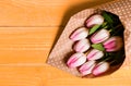 Spring is here. Happy birthday. Bouquet fresh pink tulips on yellow table background top view. Spring holiday greetings Royalty Free Stock Photo