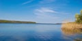 A beautiful blue sky with clouds reflected in a full-water river after melting snow. Spring high water on the Dnieper River. Royalty Free Stock Photo